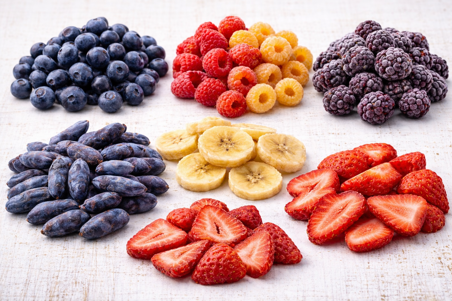 Assorted fruits including blueberries, raspberries, blackberries, bananas, and strawberries on a white surface, exclusively made for k9 prime cuts Basingstoke.